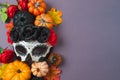 Day of the dead Mexican and Halloween holiday concept. Sugar skull mask, pumpkin and party decorations on purple background. Top Royalty Free Stock Photo