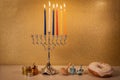 Day 5 of Hanukkah with traditional chandelier menorah, spinning top toys dreidels and a doughnut and ch Royalty Free Stock Photo