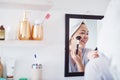 This day has me blushing for no reason. a young woman applying makeup to her face. Royalty Free Stock Photo