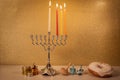 Day 3 of jewish holiday Hanukkah with traditional chandelier menorah, spinning top toys dreidels and a dohnut and ch Royalty Free Stock Photo
