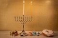 Day 1 of jewish holiday Hanukkah with traditional chandelier menorah, spinning top toys dreidels and a doughnut and ch Royalty Free Stock Photo