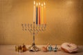 Day 4 of jewish religious holiday Hanukkah with traditional chandelier menorah, spinning top toys dreidels and a doughnut and ch Royalty Free Stock Photo