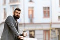 The day just started. Businessman in hipster style holding takeaway coffee. Hipster with paper cup walking in city Royalty Free Stock Photo