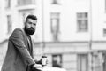 The day just started. Businessman in hipster style holding takeaway coffee. Hipster with paper cup walking in city Royalty Free Stock Photo