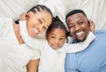 A day with Mommy and Daddy. High angle shot of an adorable little girl lying down and bonding with her parents at home. Royalty Free Stock Photo