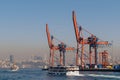 Day shot of the cranes in the shipyard of the Port of Haydarpasha, and passing ferry boat with background view of Istanbul, Turkey Royalty Free Stock Photo