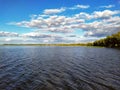 Day surface of the lake with beautiful cumulus clouds.