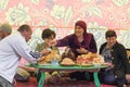 Day of the Tatar village of New Yurts. People sit in a tent at a traditional low table