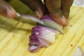 Closeup view of onion cutting with knife,Male finger and cutting board in the background Royalty Free Stock Photo