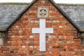 Day Viev of White Cross on Church brick wall in England