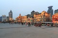 Day view of the Bund of Shanghai and the bronze bull and some tourists passing by