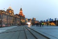 Day view of the Bund of Shanghai and the bronze bull and some tourists passing by