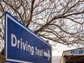 Day view driving test blue directional sign post in england uk