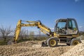 Yellow excavator with a shovel in action at the construction site Royalty Free Stock Photo