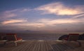 Daybed with umbrella on wooden terrace at twilight sea view,