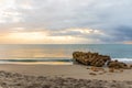 Daybreak over Calm Seas and a Rocky Beach Royalty Free Stock Photo