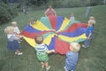 Daycare children playing a parachute game Royalty Free Stock Photo