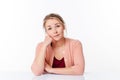 Daydreaming beautiful 20s blond woman sitting at sparse desk Royalty Free Stock Photo