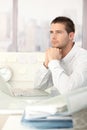 Daydreaming businessman sitting at desk Royalty Free Stock Photo