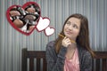 Daydreaming Girl Next To Floating Hearts with Chocolates