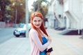 Daydreaming. Happy redhead young girl woman standing outdoor near apartment building looking back smiling happy Royalty Free Stock Photo