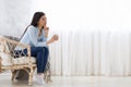 Daydreaming. Thoughtful Asian Woman Relaxing With Coffee In Wicker Chair At Home Royalty Free Stock Photo