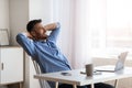 Daydreaming At Work. Successful entrepreneur relaxing at workplace with hands behind head