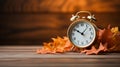 Daylight saving time. Alarm clock and orange leaves. Autumn fall. Winter approaches.