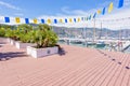 Daylight sunny view to sidewalk with chairs and flowers near port Royalty Free Stock Photo