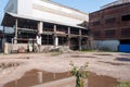 Abandoned Industrial Complex with Corrugated Metal Plant Brick Building Puddles and Vegetation Royalty Free Stock Photo