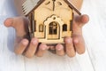 daylight. on a wooden background, in children& x27;s hands a toy house. Close-up Royalty Free Stock Photo