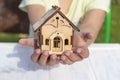 daylight. on a wooden background, in children& x27;s hands a toy house. Close-up Royalty Free Stock Photo