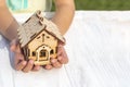 daylight. on a wooden background, in children& x27;s hands a toy house. Close-up Royalty Free Stock Photo