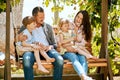 These are the days that kids will remember forever. a family of four relaxing together on a garden swing and blowing Royalty Free Stock Photo