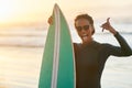 Days spent at the beach are always the best. Portrait of a beautiful young female surfer posing with her surfboard at Royalty Free Stock Photo