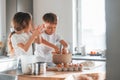 At daytime. Little boy and girl preparing Christmas cookies on the kitchen Royalty Free Stock Photo