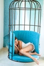 Daytime sleep of tired girl in cage chair. total relaxation. sweet and comfort dream, morning. woman sleep in iron cage