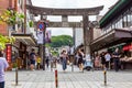 Tourists and local japanese people walk along the main road, surrounded by shops, leading to the famous Tenmangu Shrine in Dazaifu