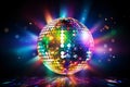 A dazzling disco ball hangs above a dark dance floor, casting colorful reflections of light