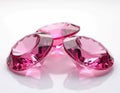 Dazzling pink gemstones shine on transparent background. Three diamonds close-up symbolize wealth, luxury. Precious ruby color