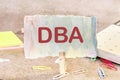 DBA is a word on paper on the table. DBA - short for doing business as