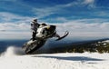RIDER MAN WITH HELMET JUMPING WITH A SNOWMOBILE IN THE SUMMIT IN WINTER Royalty Free Stock Photo