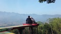 A couple sitting in the View point and selfie photo spot in Punthuk Setumbu Hills, Magelang, Central Java Royalty Free Stock Photo