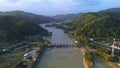 Aerial drone view of the Serayu River, the highway and railroad tracks on the side, with a background of hills, green pine forests Royalty Free Stock Photo