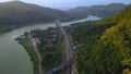 Aerial drone view of the Serayu River, the highway and railroad tracks on the side, with a background of hills, green pine forests Royalty Free Stock Photo