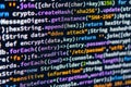 DDoS attack. Close-up view of colorful code on a computer screen, possibly C or Java Focus is on text with no