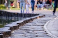 De-focus or blurred photo with people walking along the paved sidewalk in the park. Royalty Free Stock Photo