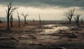 Dead trees under dramatic cloudy sky at drought cracked desert landscape Royalty Free Stock Photo