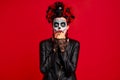 Dead gir with sugar skull makeup with a wreath of flowers on her head and skull, wearth black gloves opene her mouth in shock Royalty Free Stock Photo