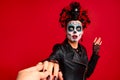 Dead gir with sugar skull makeup with a wreath of flowers on her head and skull, wearth black gloves opene her mouth in shock Royalty Free Stock Photo